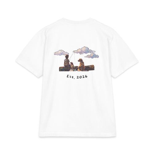 Back of white tee, painted boy fishing from a log with his two dogs under drifting clouds, Est. 2026 underneath